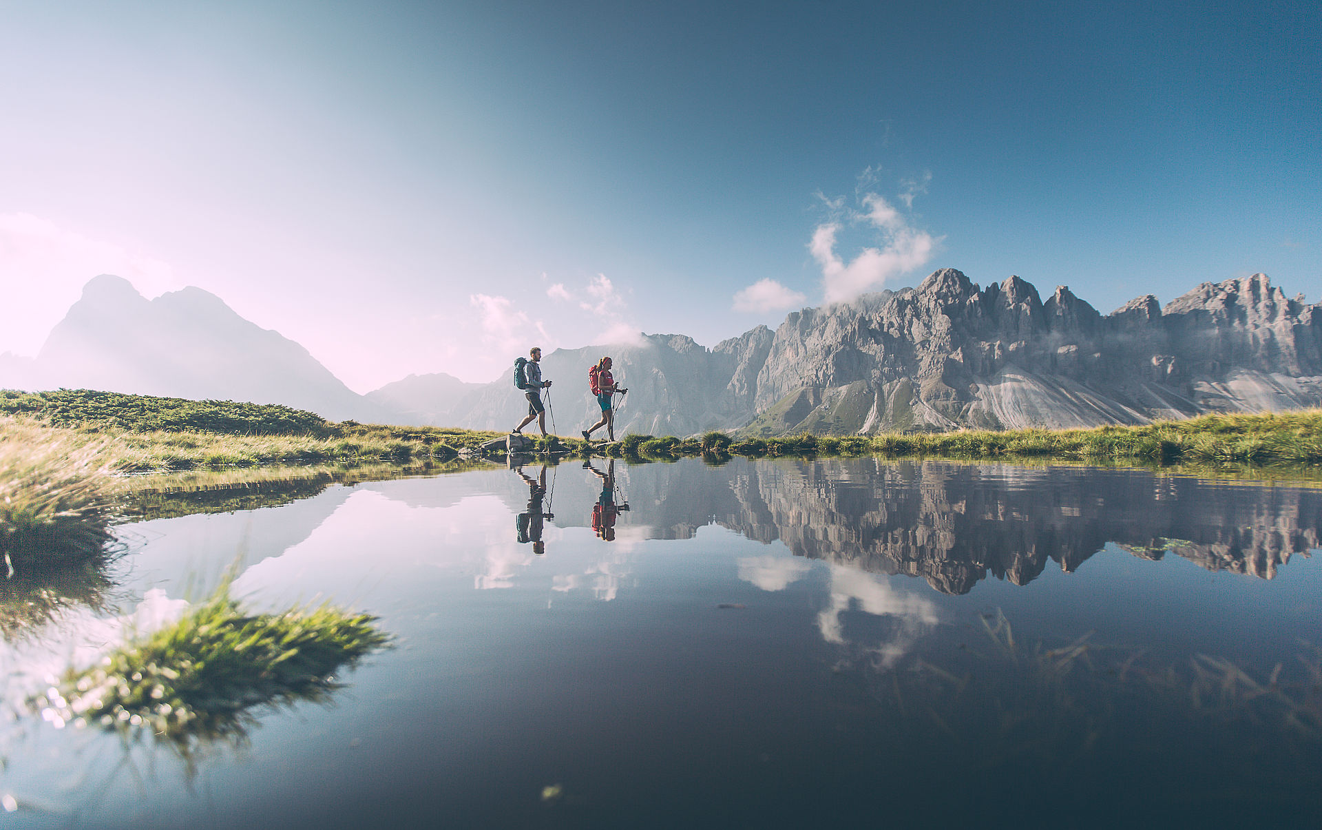 Wanderer mit Bergsee und Dolomitenpanorama im Hintergrund