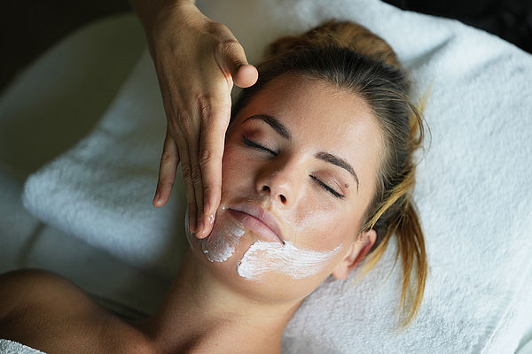 Young woman enjoys a facial massage