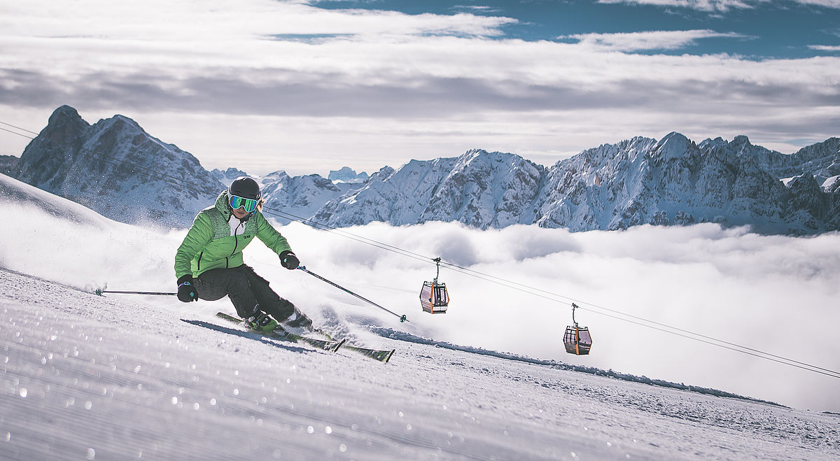 Skifahrer auf den herrlichen Skipisten im Skigebiet Plose über dem Wolkenmeer