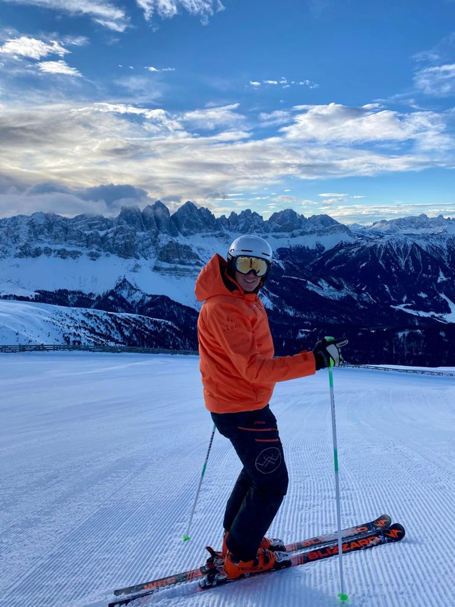 Skifahrer auf der Piste mit den Dolomiten im Hintergrund